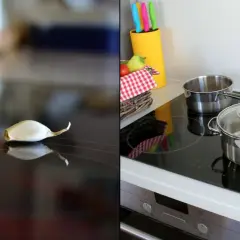 Cebula i czosnek na płycie ceramicznej czy indukcyjnej, obok garnków i koszyka z warzywami.