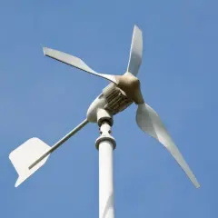Biała elektrownia wiatrowa z trzema łopatami na tle błękitnego nieba.