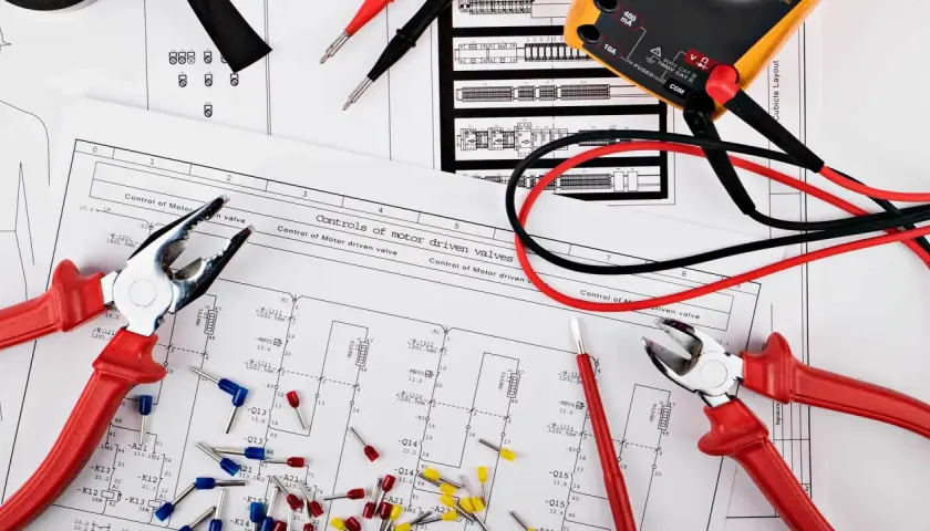 Narzędzia elektryka i schemat instalacji elektrycznej w domu.