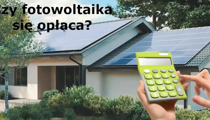 Dom z instalacją fotowoltaiczną na dachu. Kalkulator w dłoni sugeruje, że zastanawiamy się nad opłacalnością inwestycji.